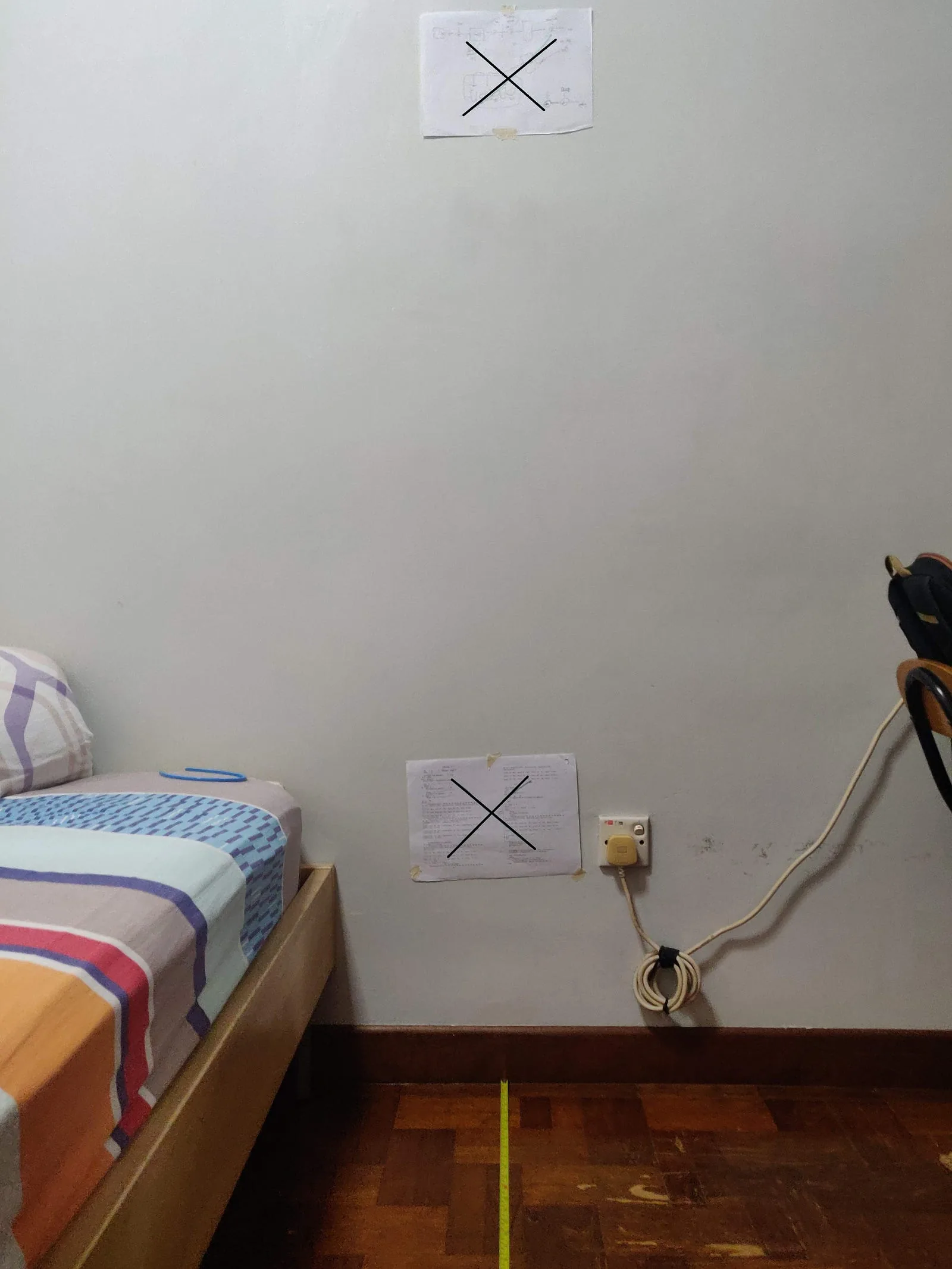 A bedroom wall marked with two crosses used as points for a focal-length measurement